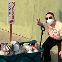 Mask Bloc LA member Abby Mahler poses with a wagon full of free high-quality masks. Image via Abby Mahler.